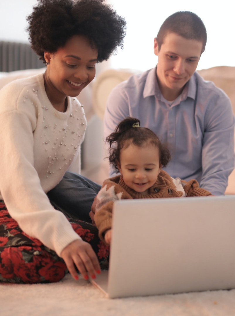 photo-of-family-sitting-on-floor-while-using-laptop-3818963